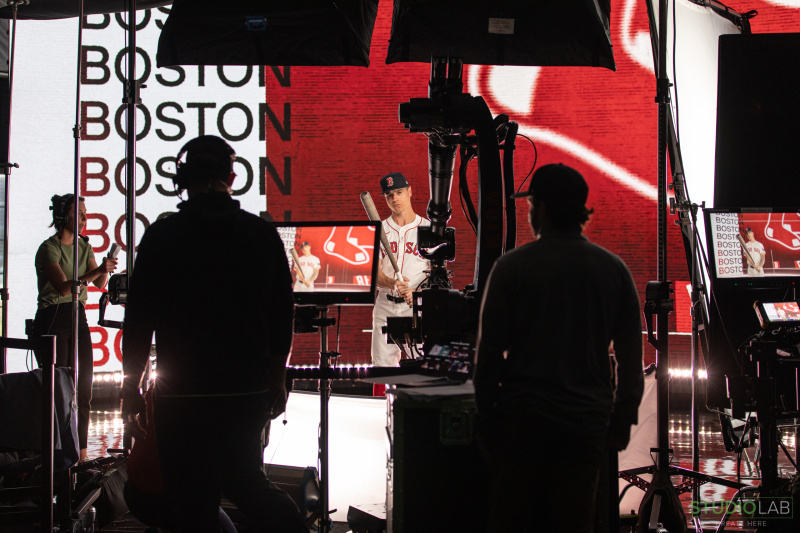 Studio image with crew observation screens and the camera as it records a player posing.